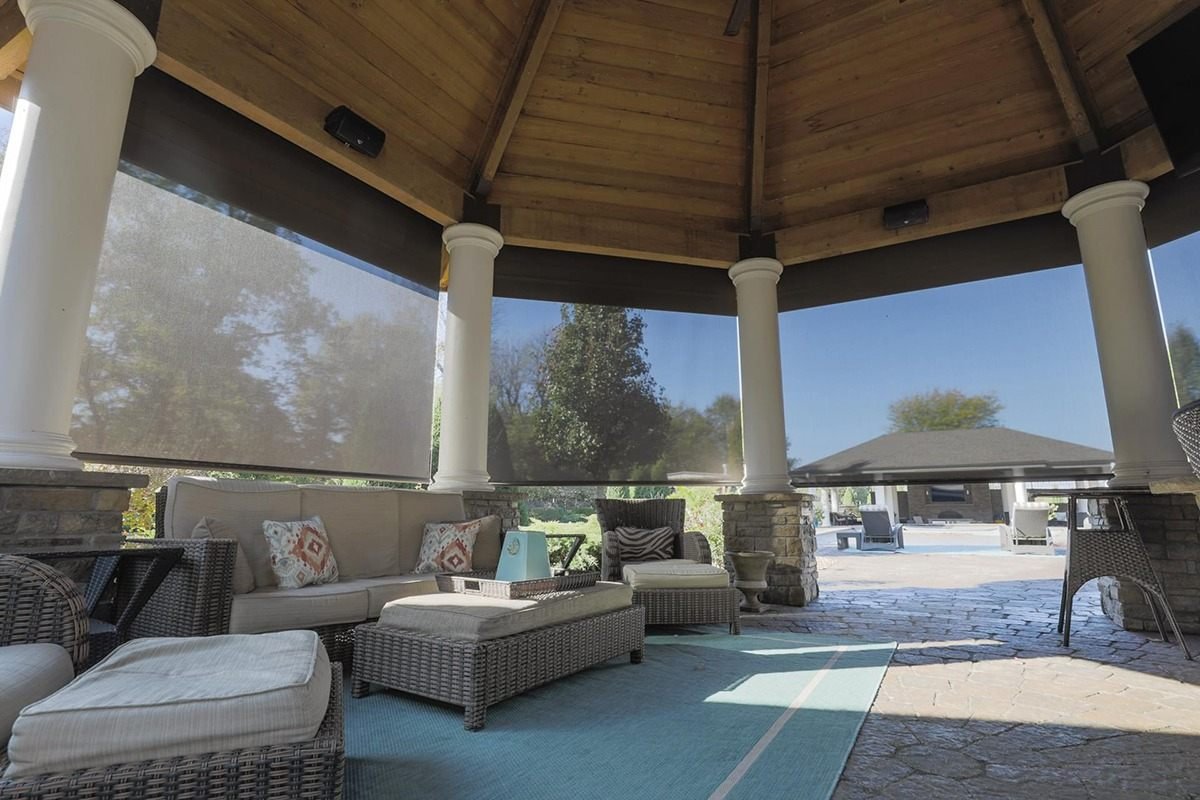 Motorized shades enclosing a covered outdoor lounge